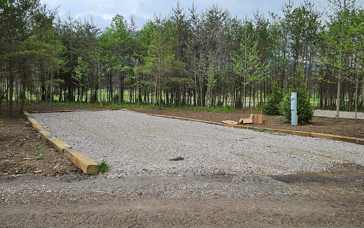 Camp trailer set up in campground site with bicycles